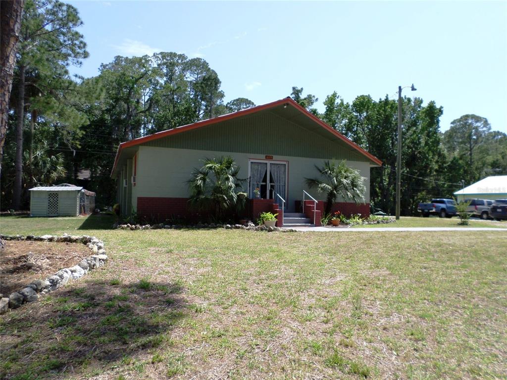 A single-story building with a green facade, brick base, and a gabled roof — 6005 HIGHWAY 40 W, YANKEETOWN, FL