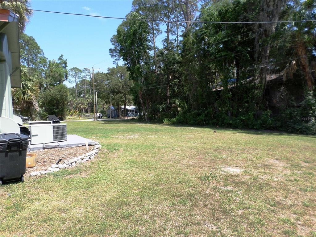 A grassy, open lot sits next to a house with an outdoor air conditioning unit — 6005 HIGHWAY 40 W, YANKEETOWN, FL