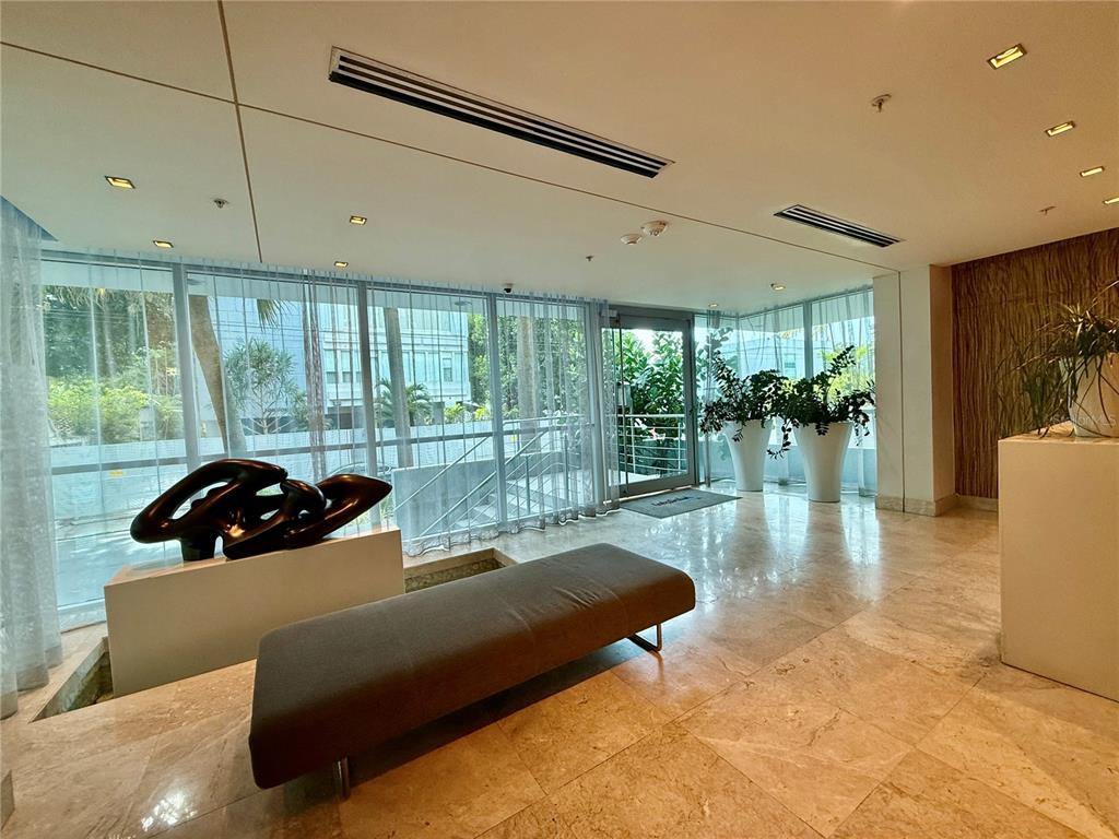 A modern lobby features a gray bench, abstract sculpture, floor-to-ceiling windows, and marble flooring — 7 C.  MANUEL RODRIGUEZ SERRA UNIT 9, SAN JUAN, PR