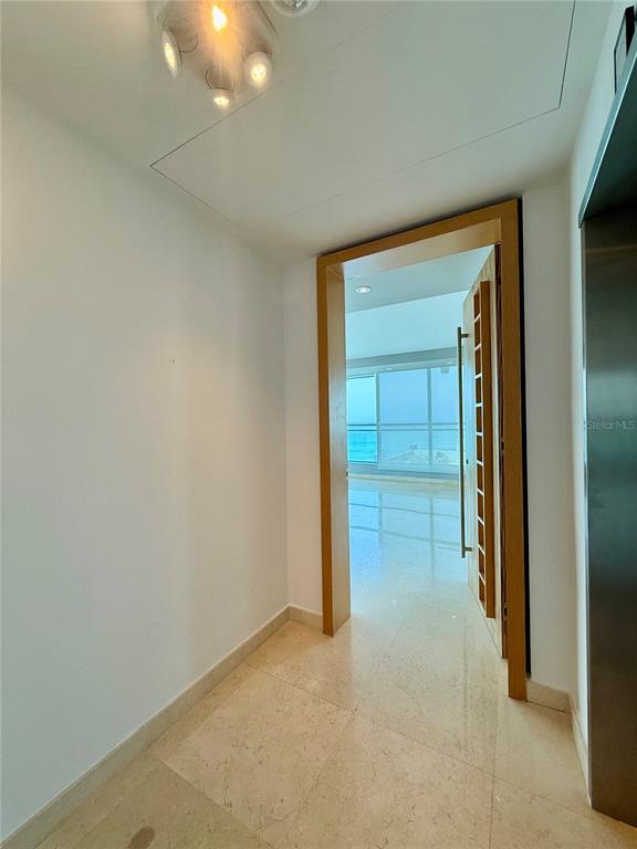 A hallway with light-colored tile flooring leads through a wooden doorway to a bright room — 7 C.  MANUEL RODRIGUEZ SERRA UNIT 9, SAN JUAN, PR