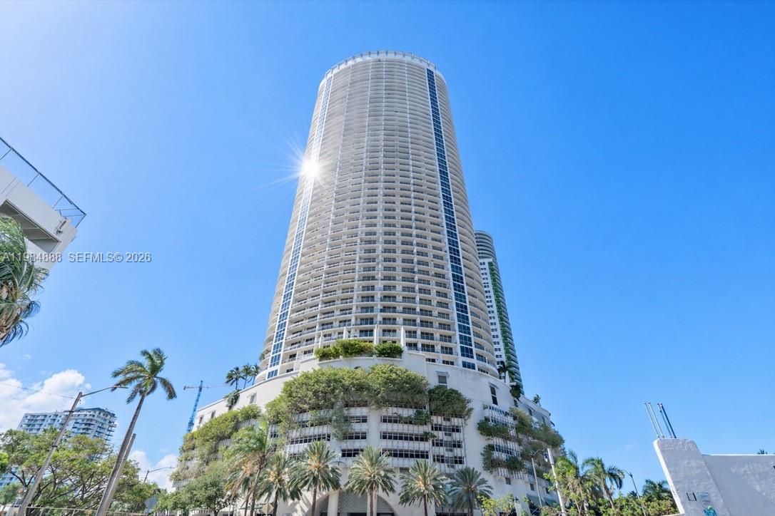 A low-angle view of a tall, cylindrical residential skyscraper with a parking garage base — 1750 N Bayshore Dr # 3811, Miami FL 33132, MIAMI, FL