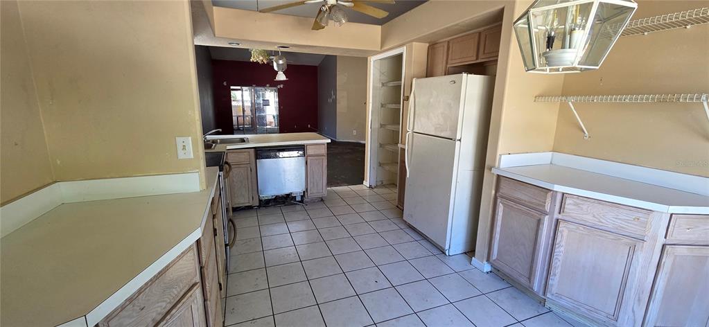 A kitchen with light wood cabinets, white countertops, tile flooring, and a white refrigerator — 2115 INTERVISTA LANE, VALRICO, FL