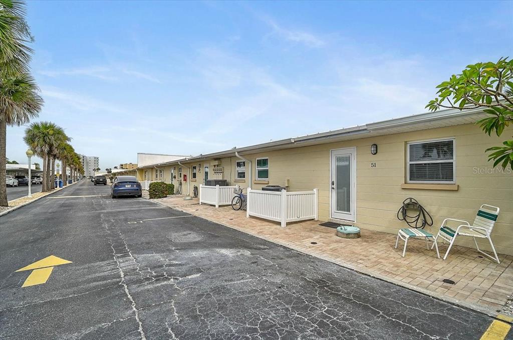 An exterior view of a single-story apartment building with a paved parking area — 5830 MIDNIGHT PASS ROAD UNIT 51, SARASOTA, FL