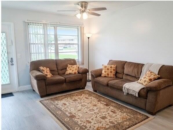 A living room features two brown sofas, a patterned area rug, and a ceiling fan — 25 Upminster B # 25, Deerfield Beach FL 33442, DEERFIELD BEACH, FL