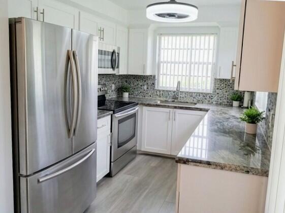 A kitchen with white cabinets, stainless steel appliances, and granite countertops — 25 Upminster B # 25, Deerfield Beach FL 33442, DEERFIELD BEACH, FL