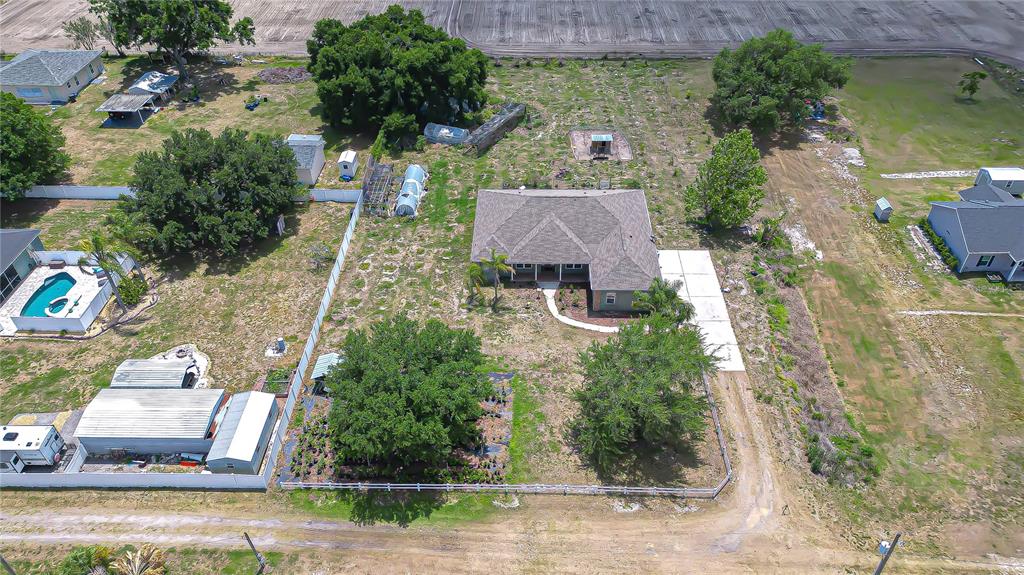 An aerial view shows a house with a large yard, trees, and outbuildings — 4036 MOORES LAKE ROAD, DOVER, FL