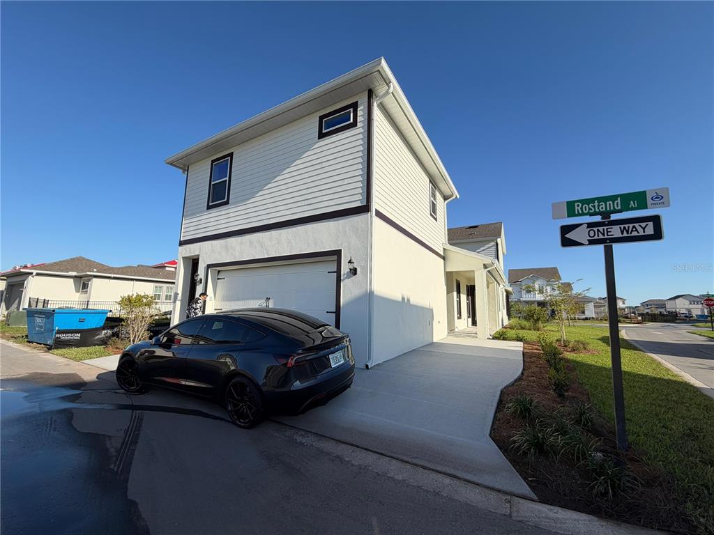 A two-story house with white siding and a black car parked in the driveway — 10373 ROSTAND ALLEY ST STREET, ORLANDO, FL