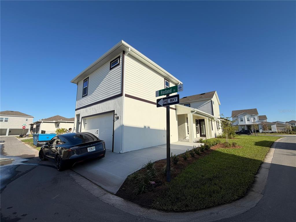 A two-story house with a white exterior, a one-car garage, and a black car parked outside — 10373 ROSTAND ALLEY ST STREET, ORLANDO, FL