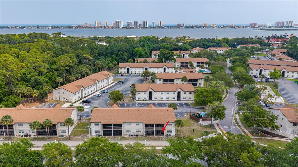 An aerial view shows a multi-story apartment complex with brown roofs and surrounding green trees — 428 BANANA CAY DRIVE UNIT A, SOUTH DAYTONA, FL