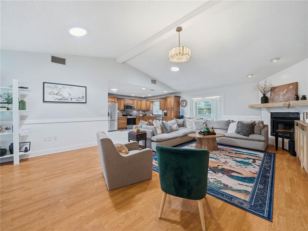 A living room with hardwood floors, a sectional sofa, and an open kitchen in back — 955 TIMBERGREEN DRIVE, LAKELAND, FL