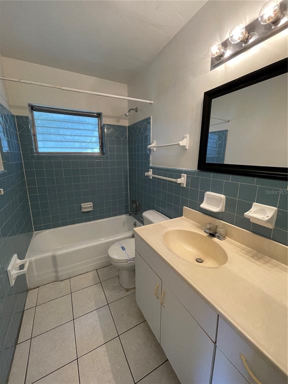 A bathroom features blue tiled walls, a white bathtub, a vanity, and a wall mirror — 1600 INDIANA AVENUE, WINTER PARK, FL