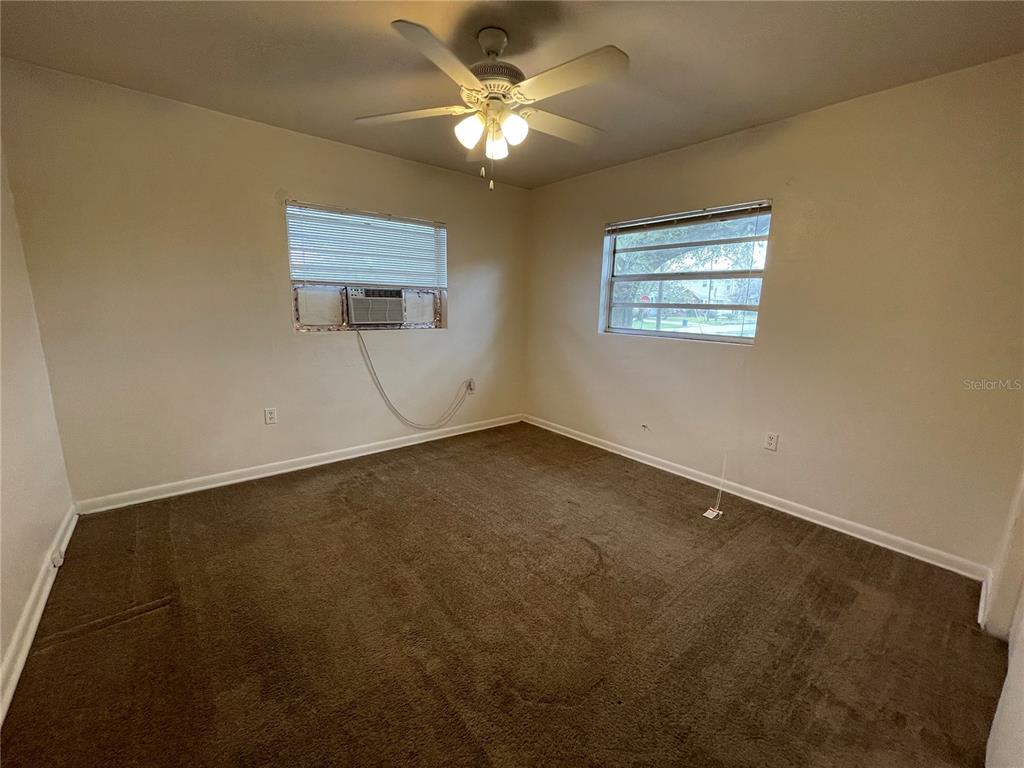 An empty bedroom features brown carpet, white walls, a ceiling fan, and two windows — 1600 INDIANA AVENUE, WINTER PARK, FL