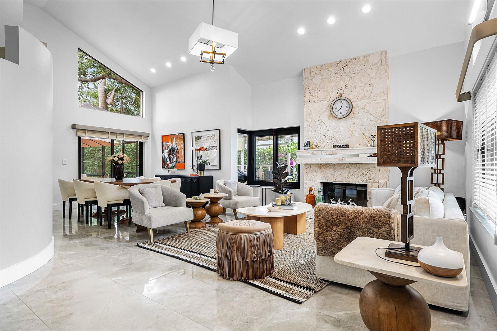 A bright living and dining area features a stone fireplace, vaulted ceilings, and tile flooring — 20797 Cabrillo Way, Boca Raton FL 33428, BOCA RATON, FL