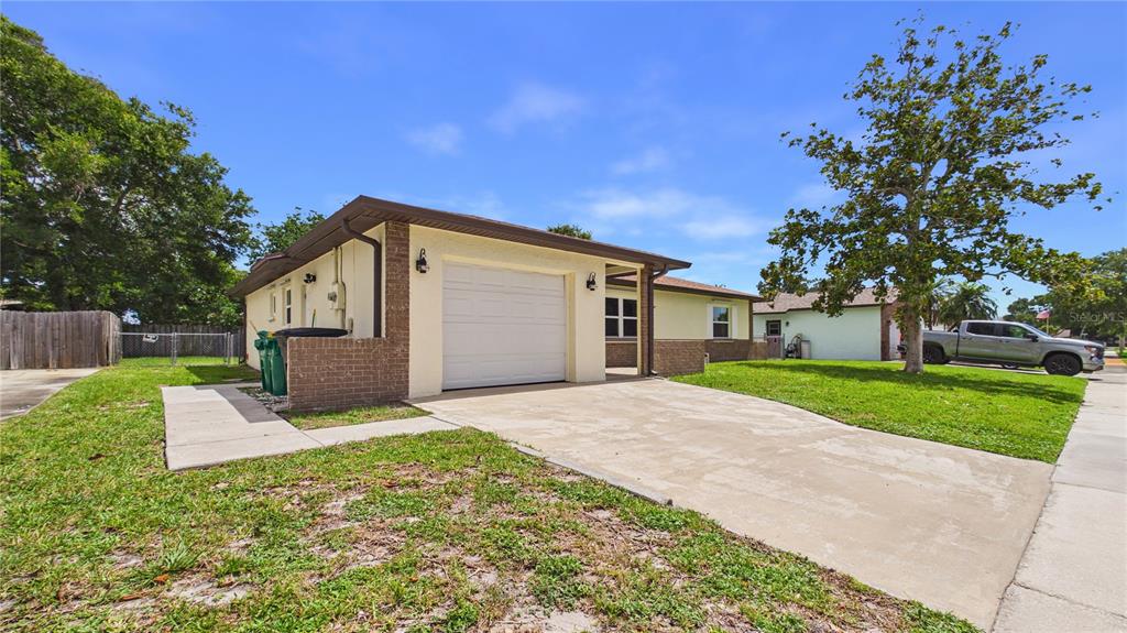 A single-story house with a white garage door, brick accents, and a concrete driveway — 1964 W SHORES ROAD, MELBOURNE, FL
