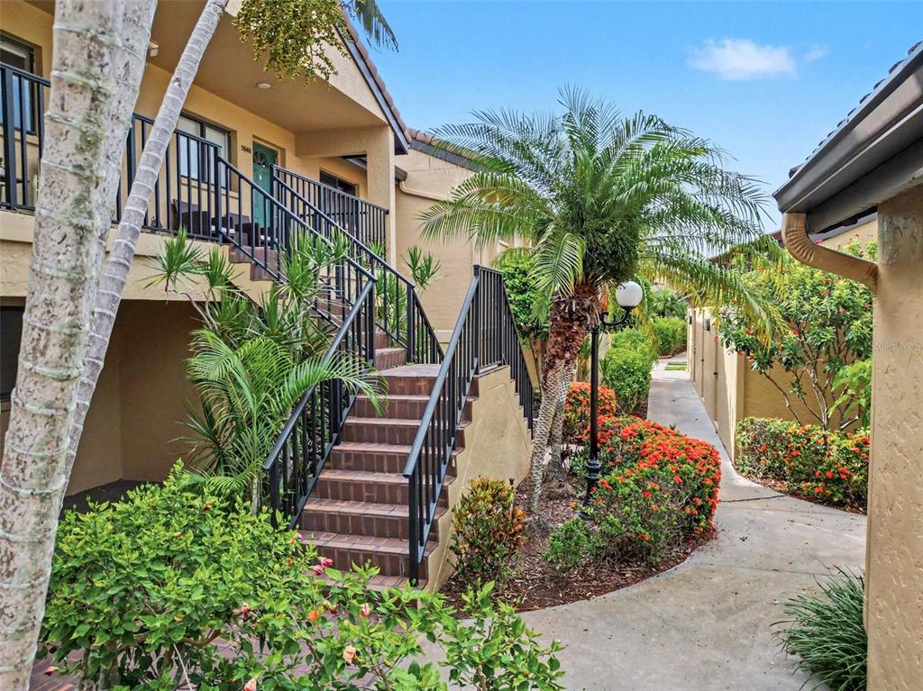 An outdoor staircase leads to a second-story balcony of a tan stucco apartment building — 5652 ASHTON LAKE DRIVE UNIT 5652, SARASOTA, FL