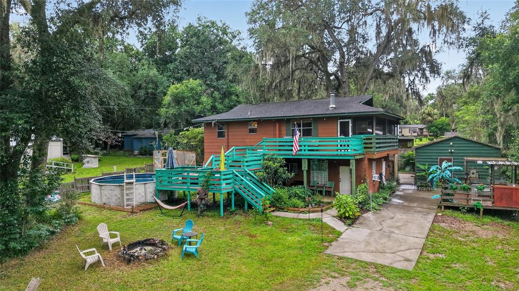 A two-story house with a large teal deck, an above-ground pool, and a detached garage — 14190 NE 199TH LANE, FORT MC COY, FL