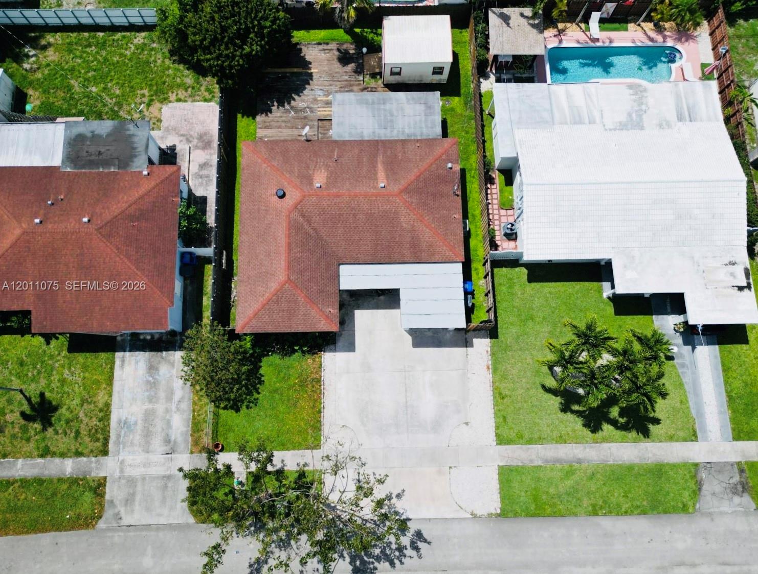 An aerial view shows three residential houses with driveways, lawns, and a backyard swimming pool — 730 N 73rd Ave, Hollywood FL 33024, HOLLYWOOD, FL