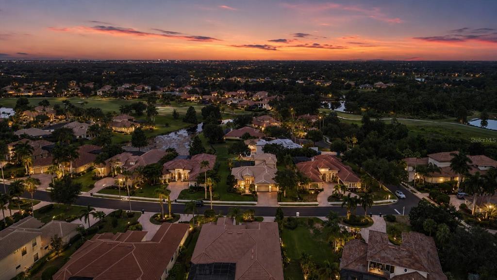 An aerial view of a single-story house with a tile roof and a paved driveway — 6806 DOMINION LANE, LAKEWOOD RANCH, FL