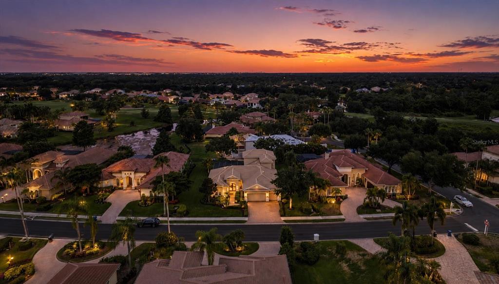 A screened-in pool patio with a hot tub, brick pavers, and views into the home — 6806 DOMINION LANE, LAKEWOOD RANCH, FL