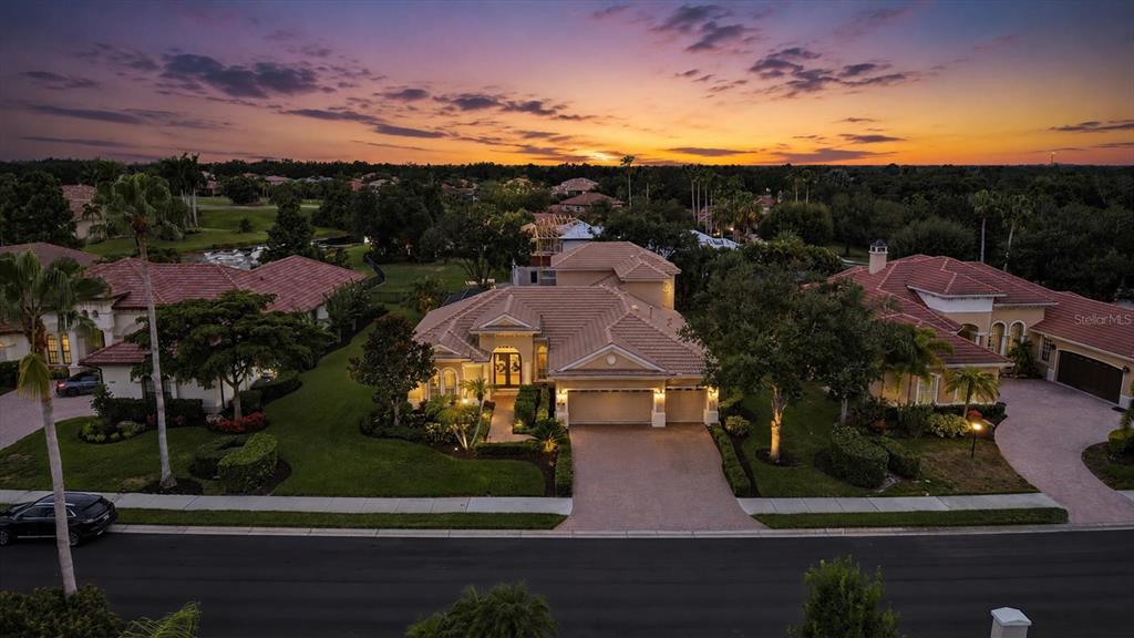A living room with a sofa, armchair, glass coffee table, and an adjacent dining area — 6806 DOMINION LANE, LAKEWOOD RANCH, FL