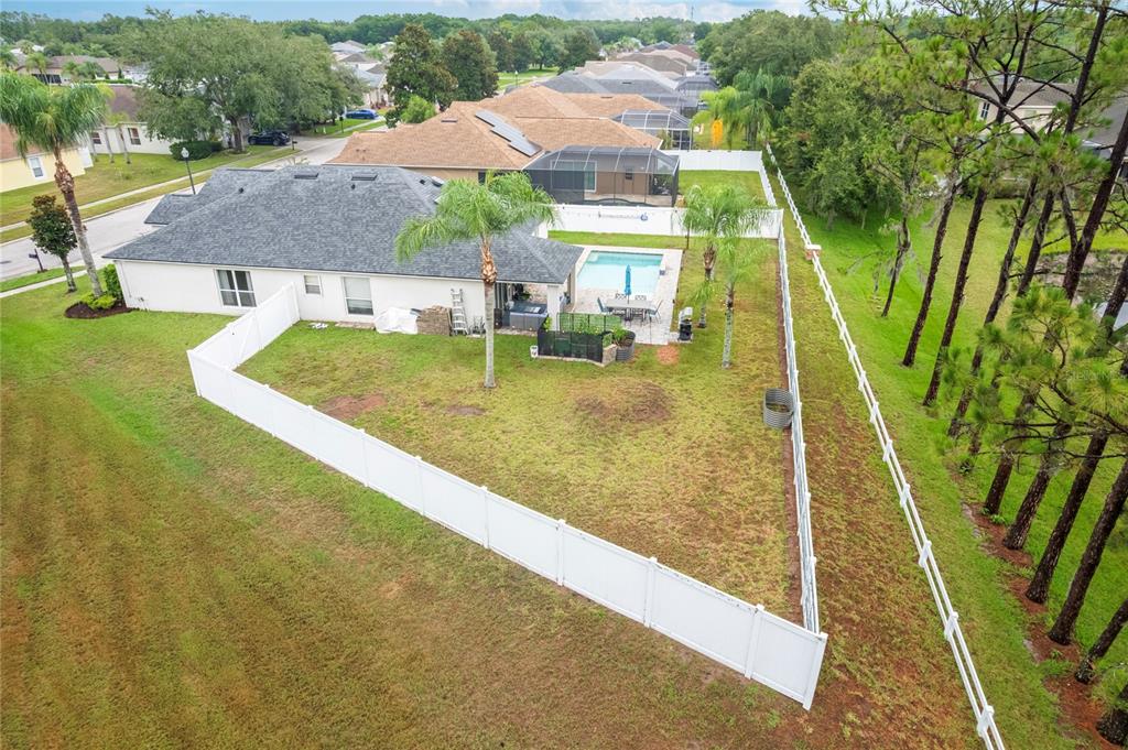 An aerial view of a suburban house with a fenced backyard, pool, and patio area — 20744 ORCHARDTOWN DRIVE, LAND O LAKES, FL