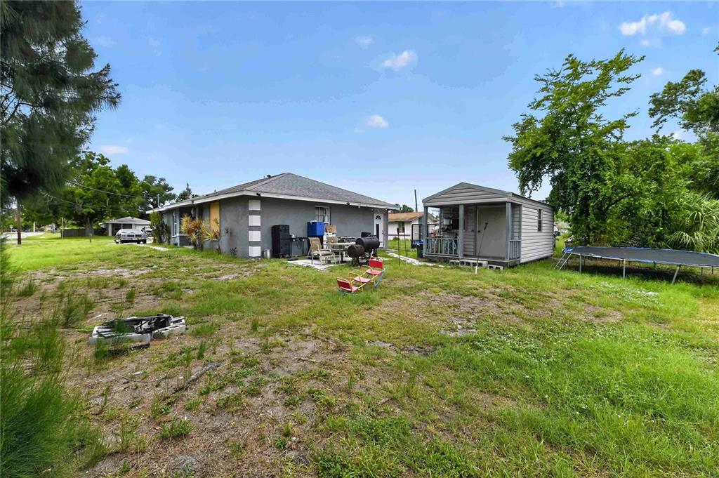 A gray house with a backyard shed, a trampoline, and a fire pit — 1904 2ND AVENUE E, PALMETTO, FL