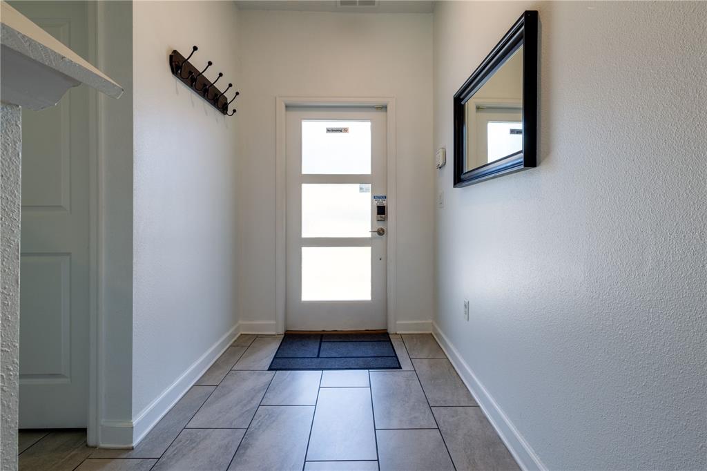 An entryway features a white door with three glass panels, tile flooring, and a wall mirror — 650 PEBBLE BEACH DRIVE, DAVENPORT, FL