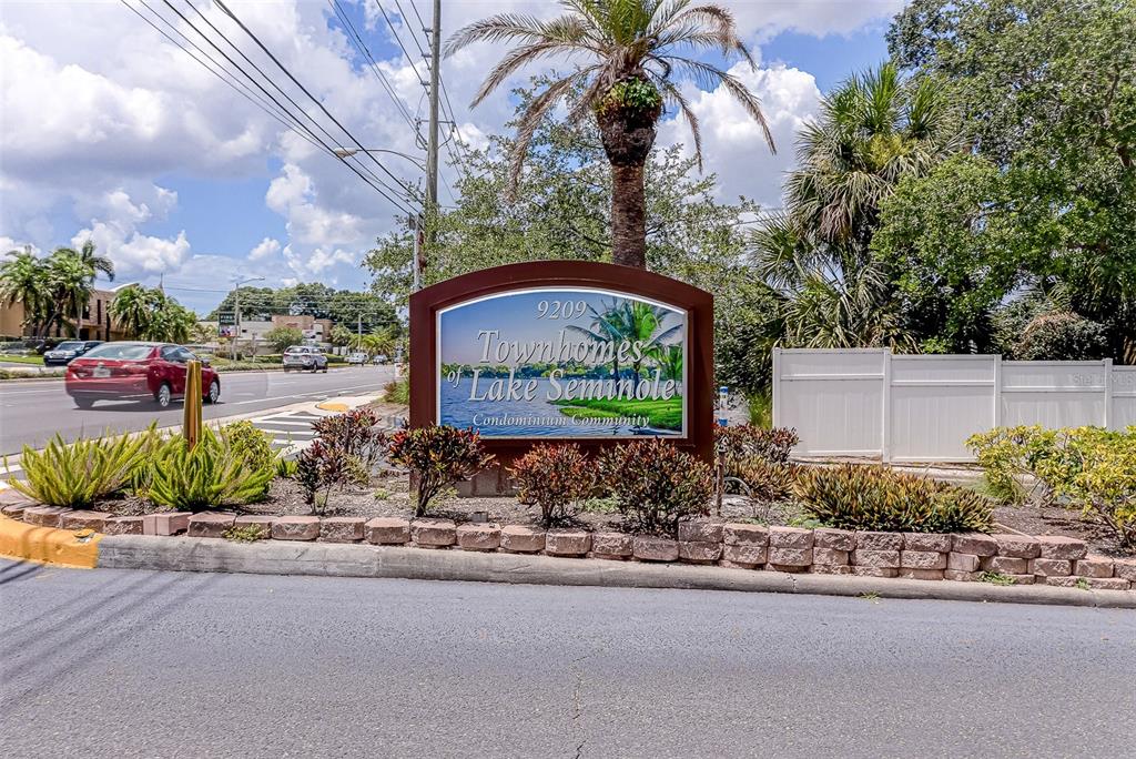 A sign for the Townhomes of Lake Seminole stands in a landscaped garden bed — 9209 SEMINOLE BOULEVARD UNIT 56, SEMINOLE, FL