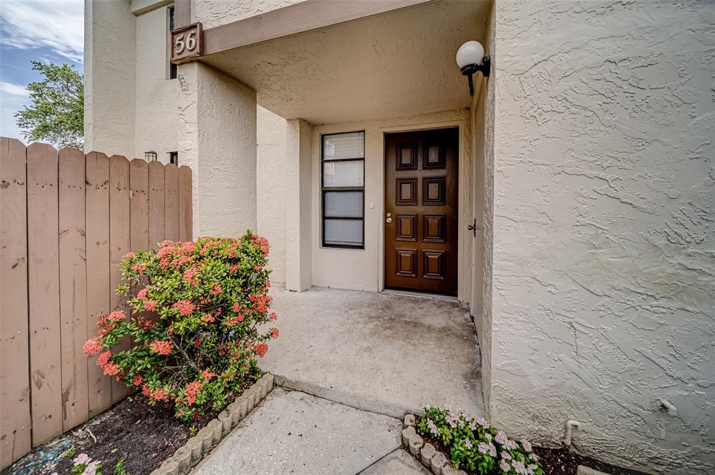 A brown front door is set in a beige stucco exterior with a small porch — 9209 SEMINOLE BOULEVARD UNIT 56, SEMINOLE, FL