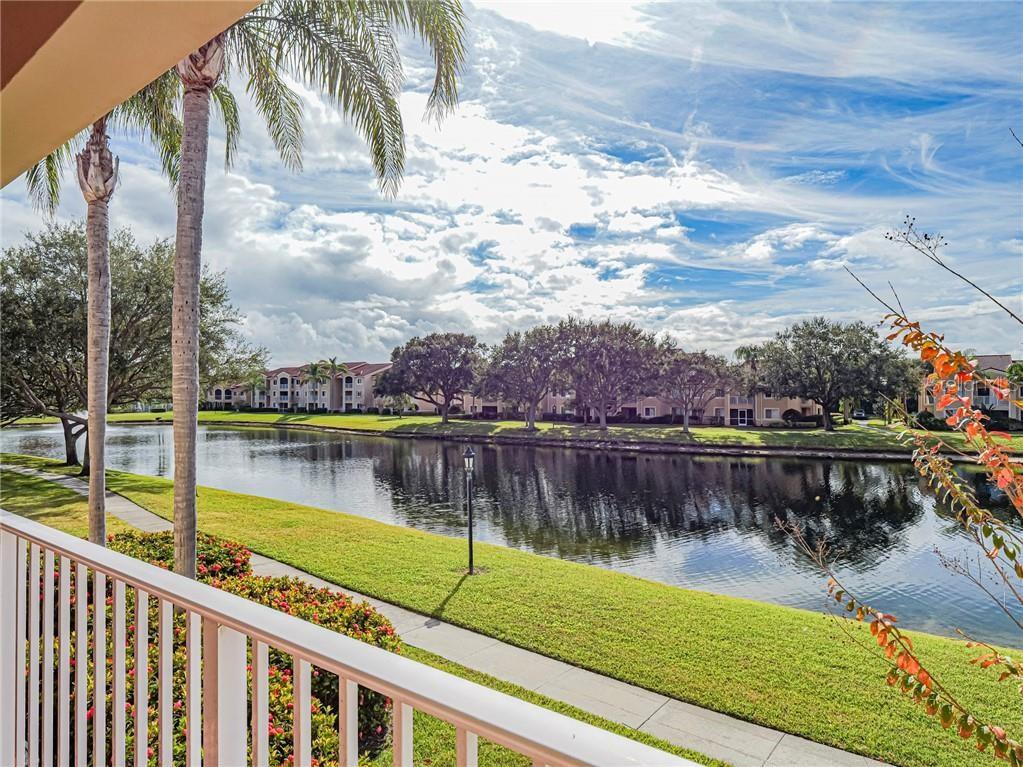 A view from a balcony overlooking a grassy lawn, a pond, and apartment buildings — 1640 N 42ND CIRCLE UNIT 206, VERO BEACH, FL