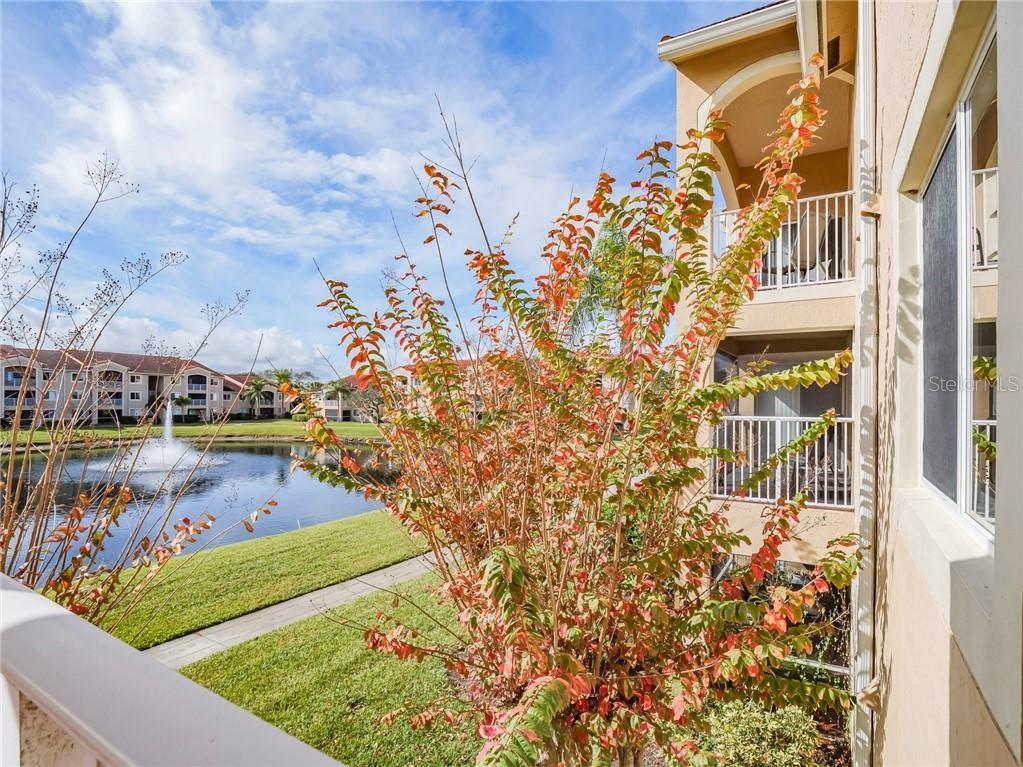A view from a balcony overlooking a pond with a fountain and apartment buildings — 1640 N 42ND CIRCLE UNIT 206, VERO BEACH, FL