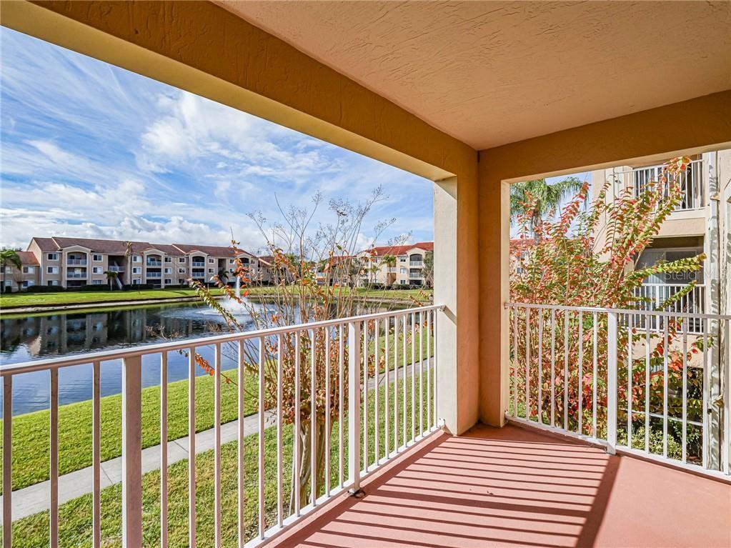 A covered balcony overlooks a pond with a fountain and surrounding apartment buildings — 1640 N 42ND CIRCLE UNIT 206, VERO BEACH, FL