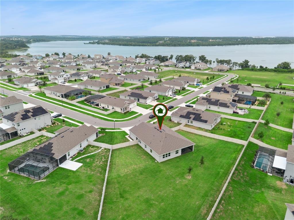 An aerial view shows a suburban neighborhood with houses, large lawns, and a nearby lake — 17954 HITHER HILLS CIRCLE, WINTER GARDEN, FL