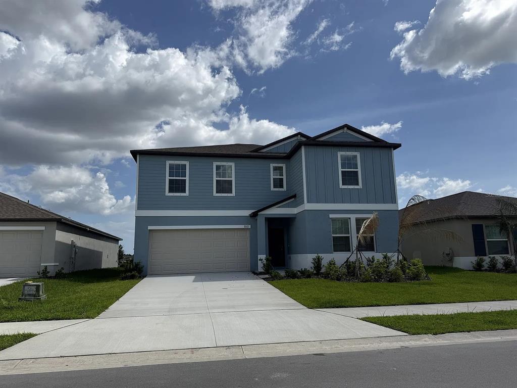 A two-story blue house with a two-car garage and a concrete driveway — 8513 8513 BLUE WAVE LN, FL, PARRISH, FL