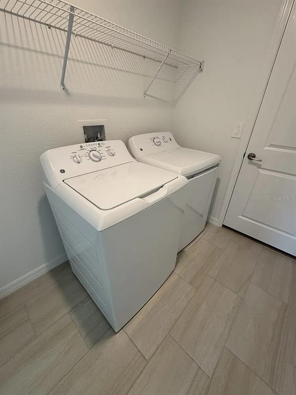 A laundry room features a white top-load washer and dryer beneath a wire shelf — 8513 8513 BLUE WAVE LN, FL, PARRISH, FL