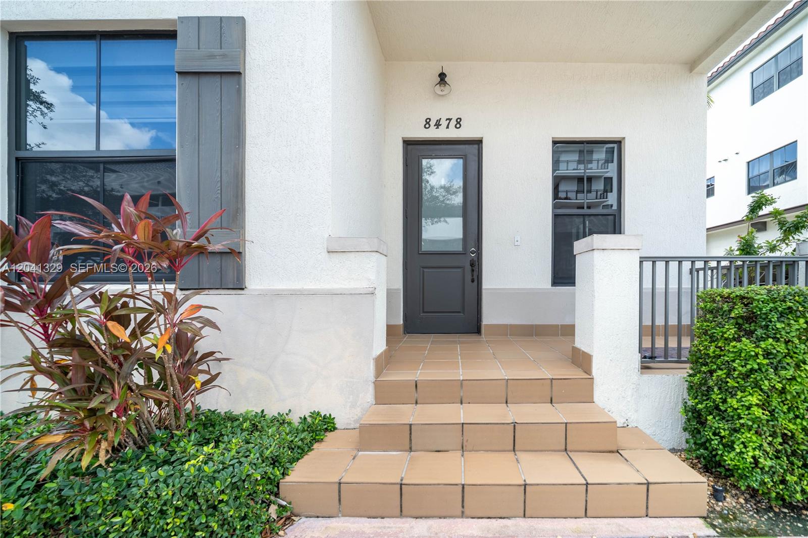 A front entrance features a dark door, tiled steps, and a window with shutters — 8478 NW 52nd St, Doral FL 33166, DORAL, FL