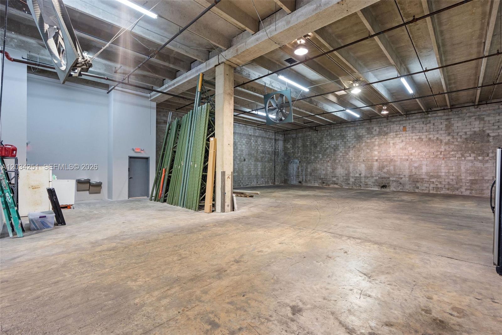 An industrial warehouse space features concrete walls, exposed ceiling beams, and a large ceiling fan — 3000 NW 79th Ave # 3000, Doral FL 33122, DORAL, FL