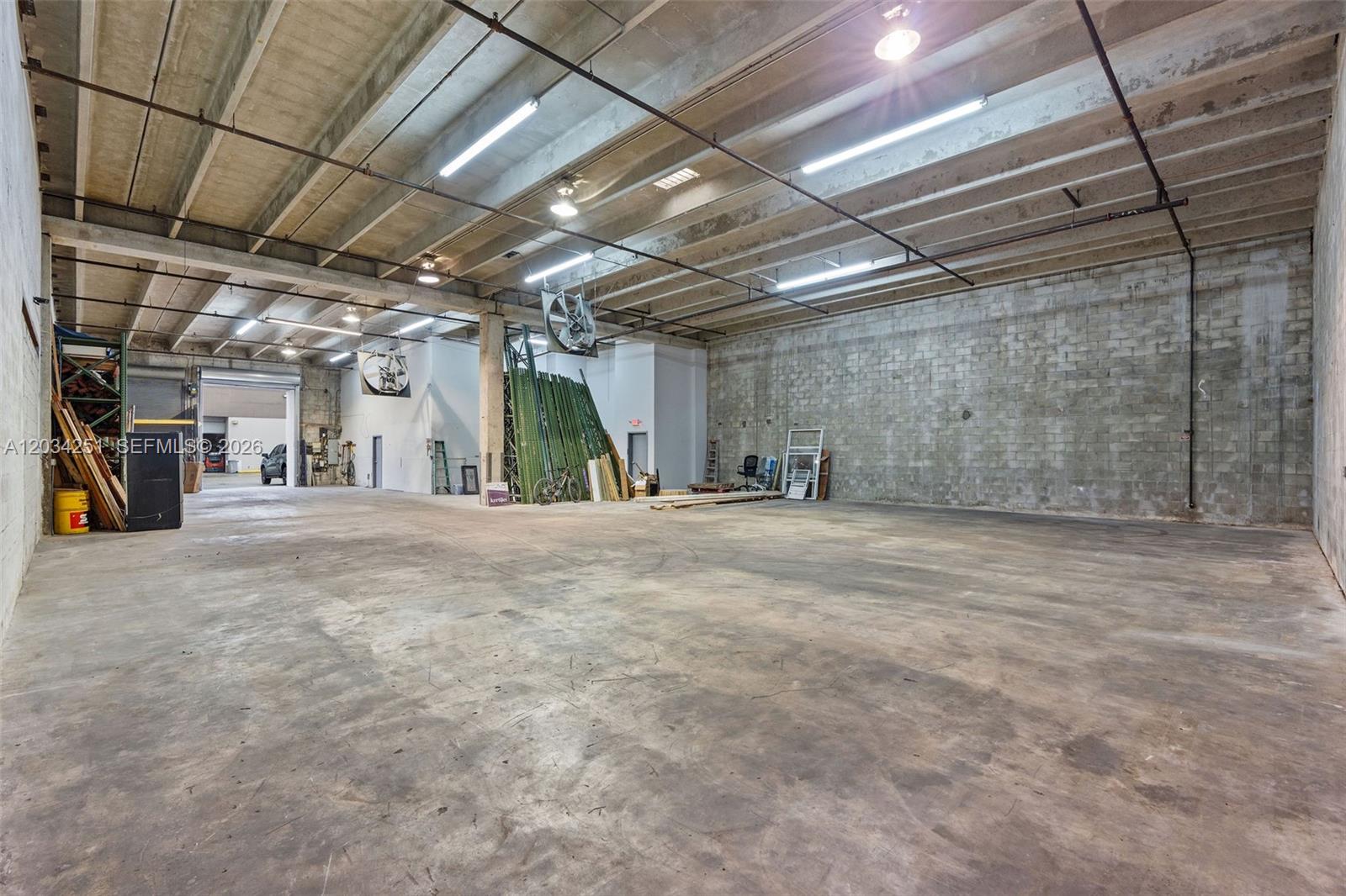 A large, open warehouse space features concrete floors, exposed ceiling beams, and block walls — 3000 NW 79th Ave # 3000, Doral FL 33122, DORAL, FL
