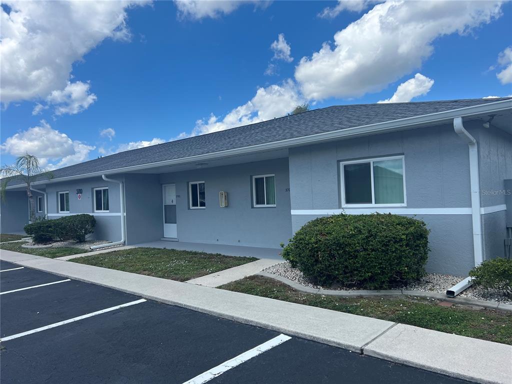 A single-story gray building with a parking lot and landscaping in front — 12274 SW EGRET CIRCLE UNIT 3703, LAKE SUZY, FL