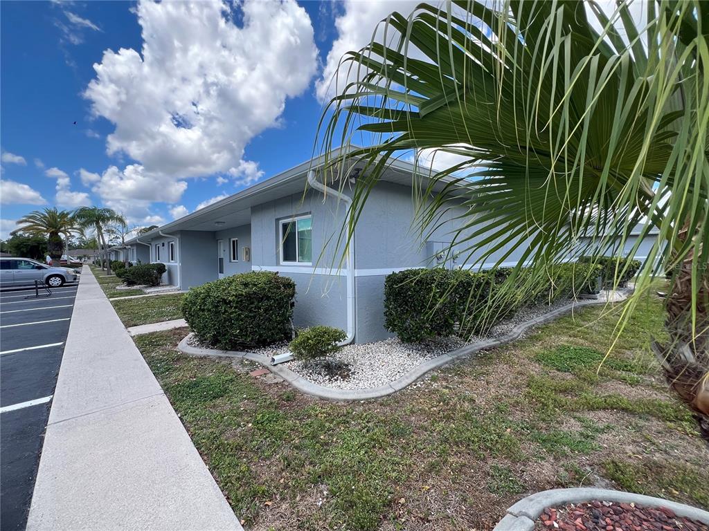 A low-rise gray apartment building with a sidewalk and parking lot in front — 12274 SW EGRET CIRCLE UNIT 3703, LAKE SUZY, FL