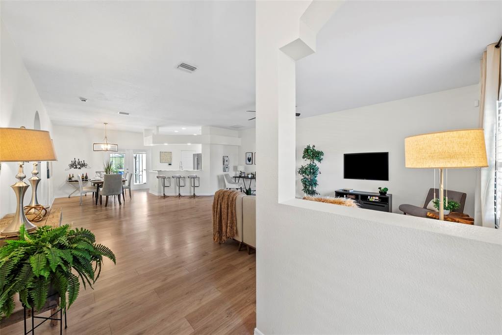 An open-concept living and dining area features light wood flooring and white walls — 350 47TH AVENUE N, ST PETERSBURG, FL