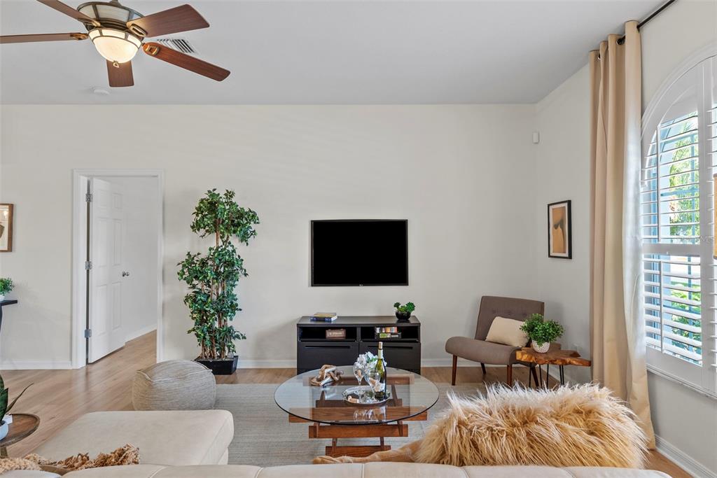 A living room features a wall-mounted television, a glass coffee table, and a ceiling fan — 350 47TH AVENUE N, ST PETERSBURG, FL