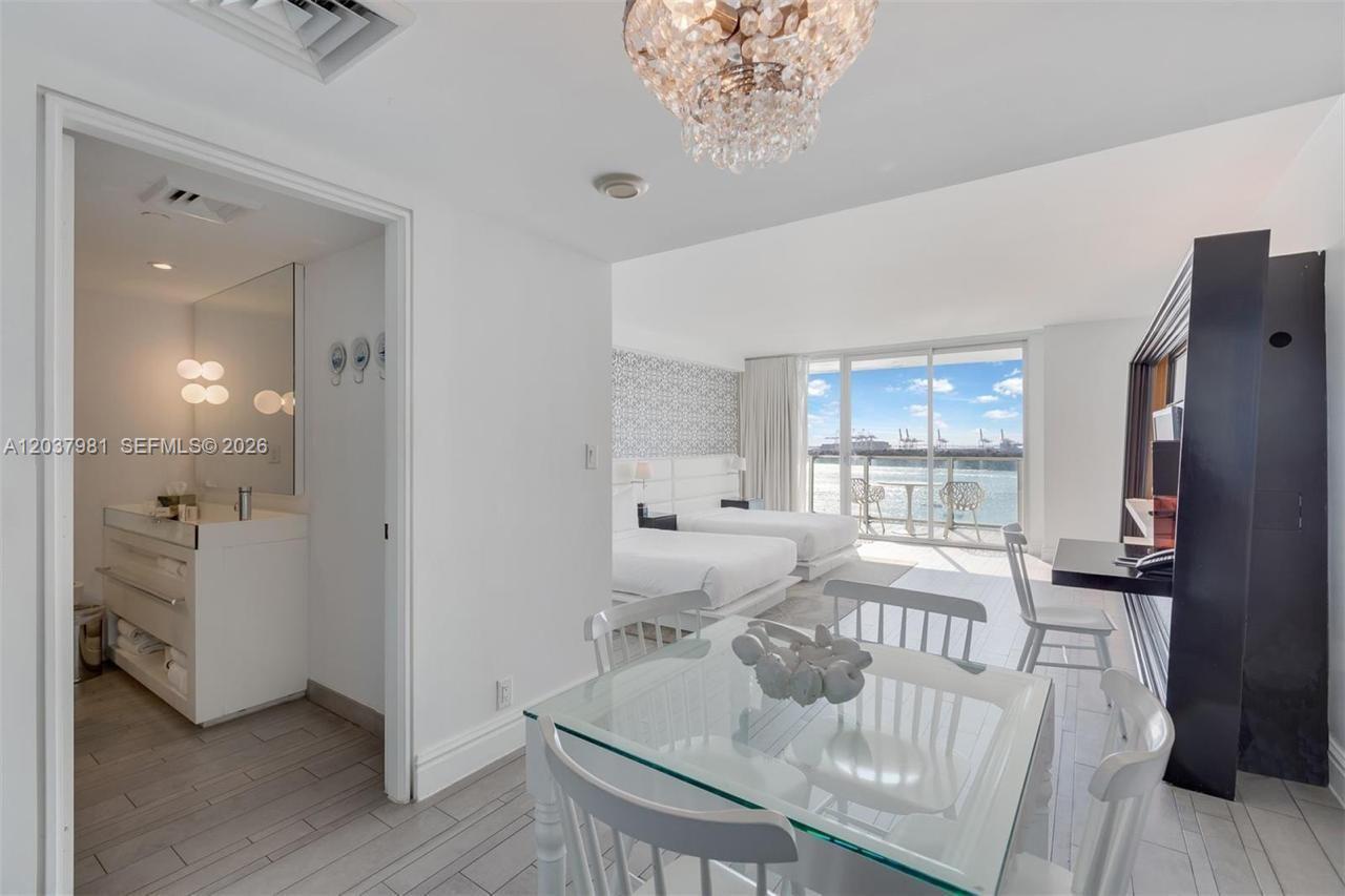A hotel room features a dining area, two beds, and a balcony overlooking the ocean — 1100 West Ave # 1012, Miami Beach FL 33139, MIAMI BEACH, FL