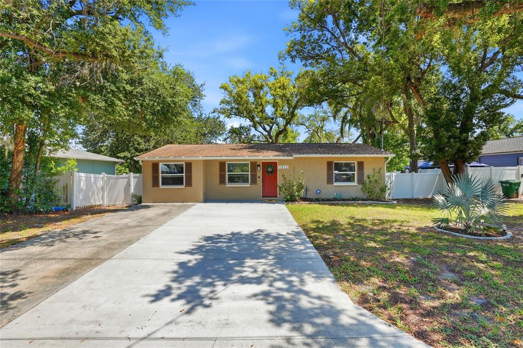 A single-story brick house with a red front door and a concrete driveway — 1512 E HANNA AVENUE, TAMPA, FL