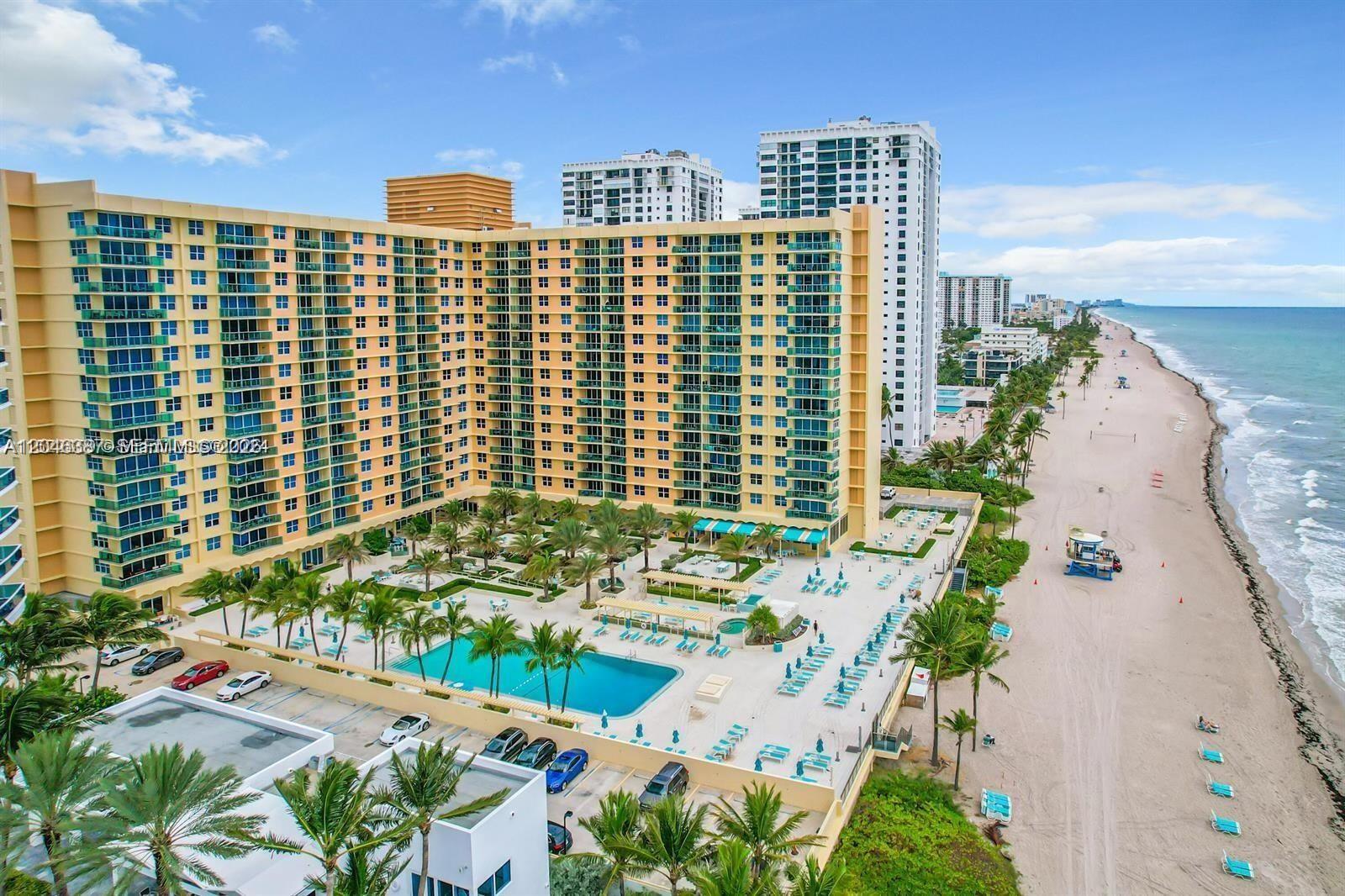 An aerial view shows a large beachfront apartment complex with a pool and palm trees — 2501 S Ocean Dr # 438, Hollywood FL 33019, HOLLYWOOD, FL