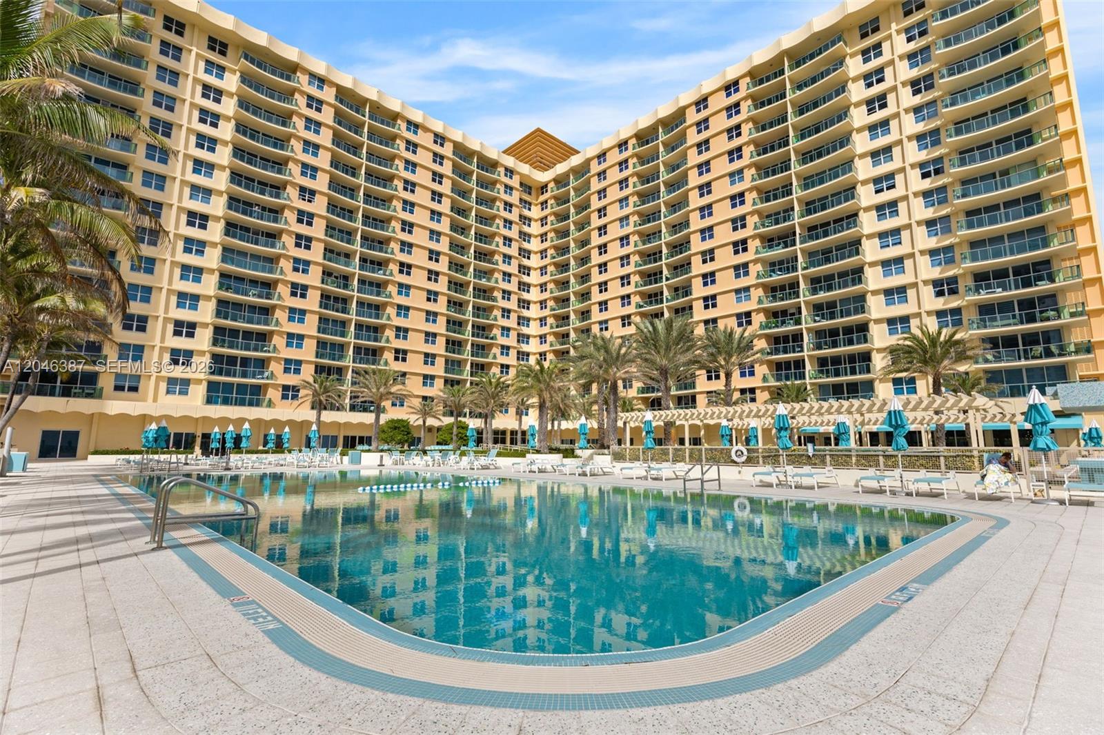 A large swimming pool sits in front of a tall, multi-story residential building — 2501 S Ocean Dr # 438, Hollywood FL 33019, HOLLYWOOD, FL