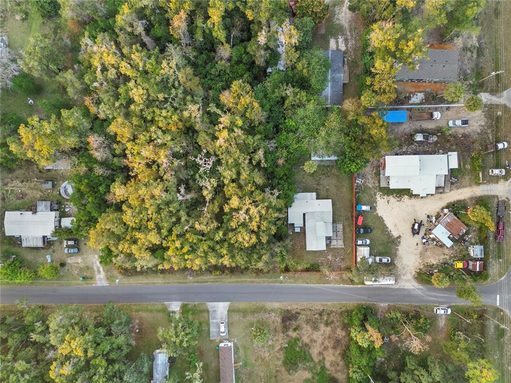 An aerial view shows a residential lot with a house, trees, and a gravel driveway — 000 W GOLDENLEAF LANE, CRYSTAL RIVER, FL