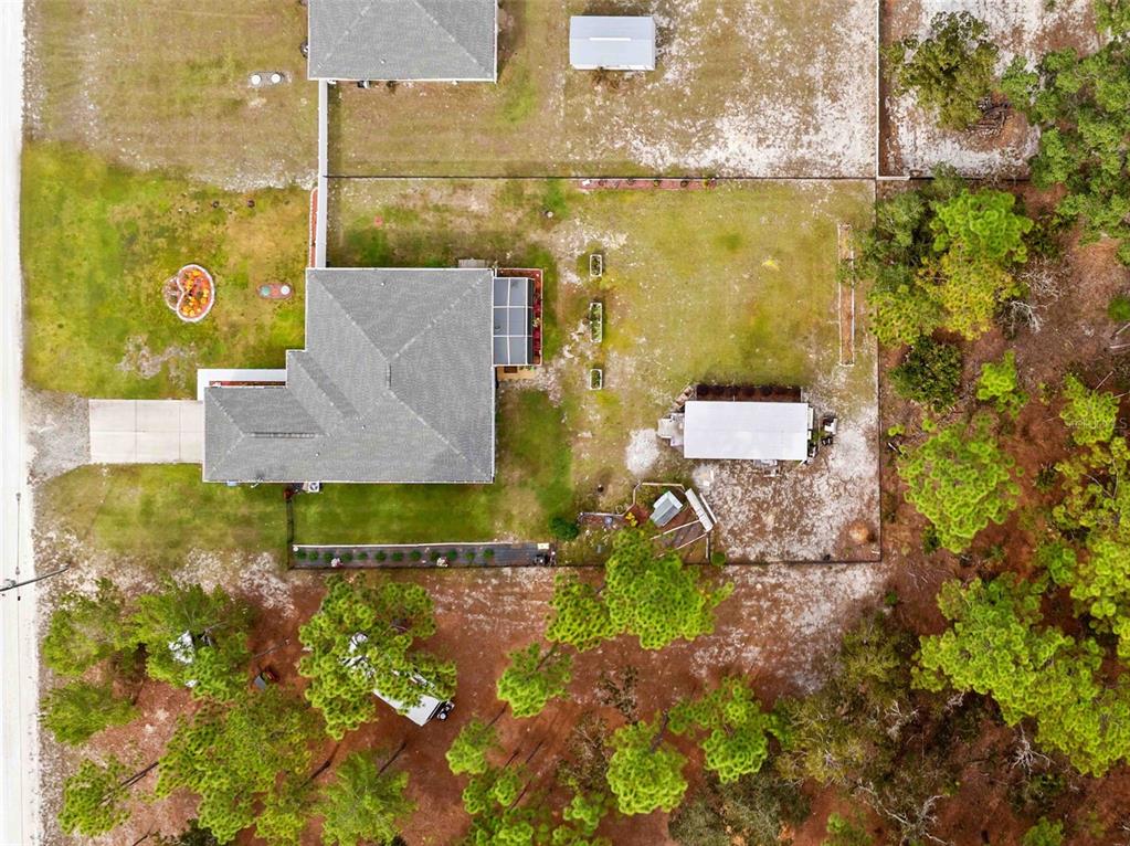 A single-story house with a stone-bordered flower bed and a flagpole in the front yard — 18062 MALIBAR ROAD, WEEKI WACHEE, FL