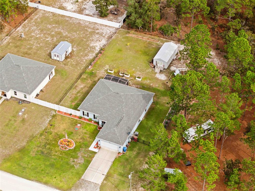 A light blue house exterior features a concrete walkway leading to the front entrance — 18062 MALIBAR ROAD, WEEKI WACHEE, FL