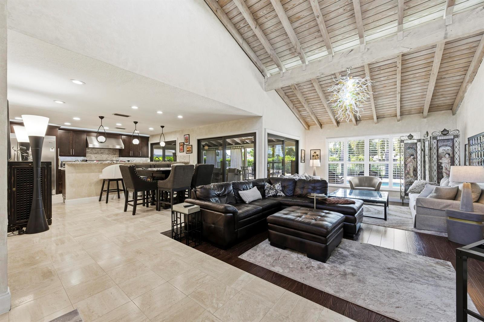An open-concept living room and kitchen feature vaulted wood-paneled ceilings and tile flooring — 11327 Wingfoot Drive, Boynton Beach FL 33437, BOYNTON BEACH, FL